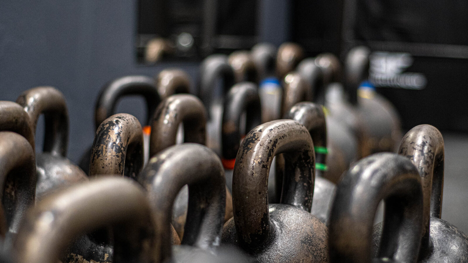 Rzędy kettlebelli różnych wag w siłowni