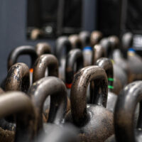 Rzędy kettlebelli różnych wag w siłowni