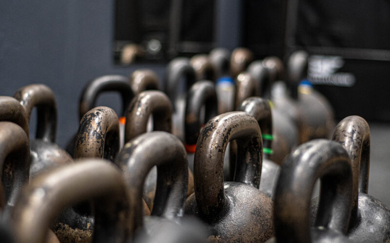 Rzędy kettlebelli różnych wag w siłowni