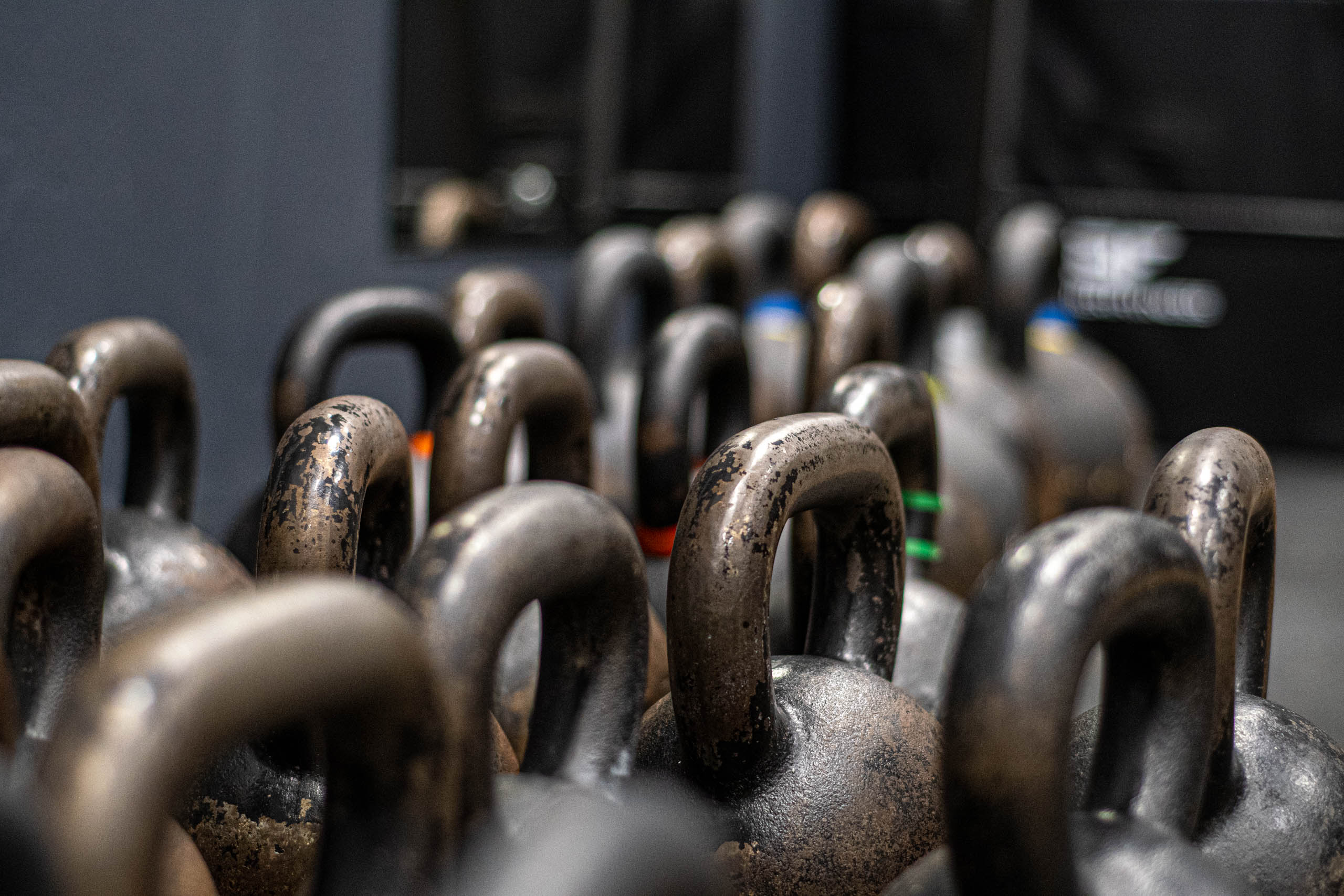 Rzędy kettlebelli różnych wag w siłowni
